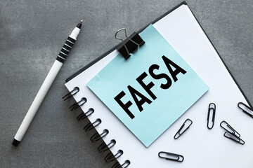 Free Application for Federal Student Aid (FAFSA). blue bulletin board sticker on notepad and...