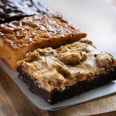 Stack of delicious dessert slices. Brownie, macadamia almond and chocolate caramel bar. Close up...
