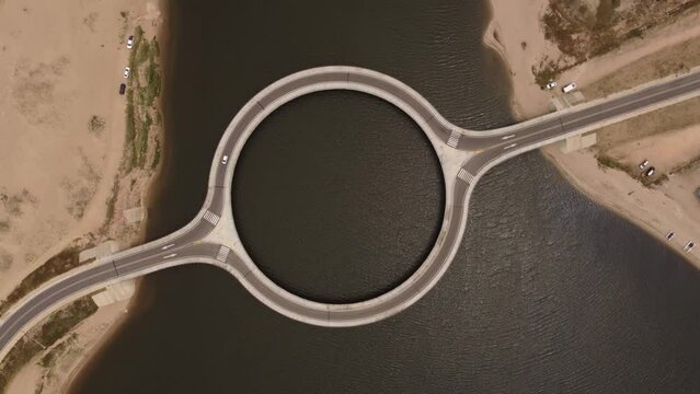 Drone rotates over Laguna Garzon circular bridge in Uruguay