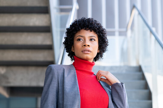 Una elegante mujer afroamericana con pelo corto en un  edificio de oficinas