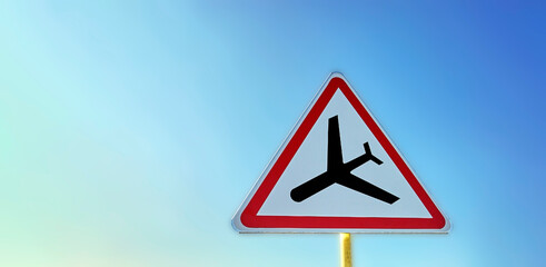 Road sign low flying planes against the sky.