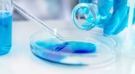 Close-up of a scientist's hand with a laboratory pipette. Equipment for chemical experiments. Scientist doing laboratory research