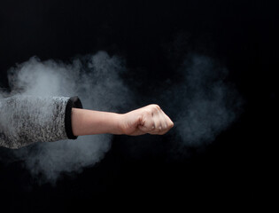 Fist on a black background, smoke
