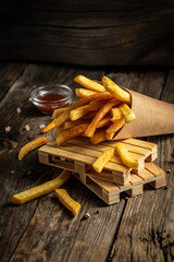 fries in paper box on wooden table. American food concept. fast food meal. banner, menu, recipe,...
