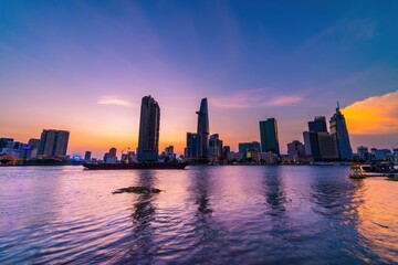 View of Bitexco Financial Tower building, buildings, roads, Thu Thiem bridge and Saigon river in Ho Chi Minh city in sunset.