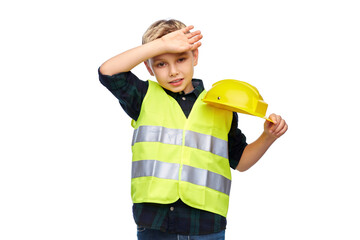 building, construction and profession concept - tired little boy in protective helmet and safety vest over white background