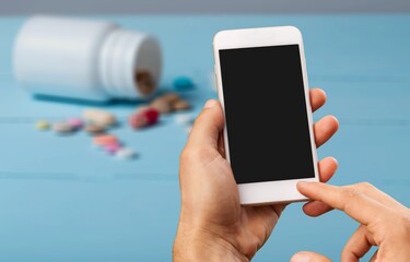 Patient hand using smartphone. Pharmaceutical use. Drugs. Pills. Prospectus. Using Smarthphone