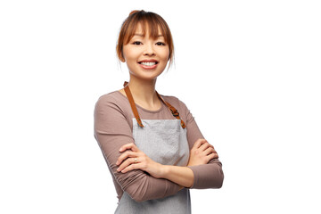 cooking, culinary and people concept - happy smiling female chef or waitress in apron with crossed...