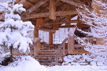 a wooden hut is like a gazebo in a winter snow-covered forest where it snows 