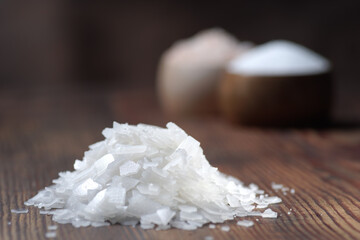 Different natural types of salt on a wooden background. Salt crystals in a wooden container