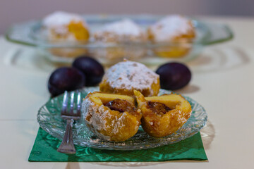 Sweet plum dumplings on a plate on the table. Homemade dessert with potatoes and plums.