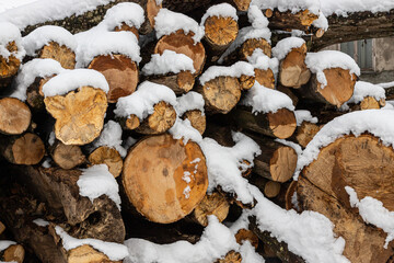 Snow covered firewood. Stack of wood cut. Snow on the timber stack. Wooden log store under snow