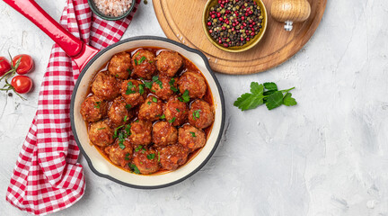 Meat or vegetable meatballs in tomato sauce in frying pan on ligh background, top view