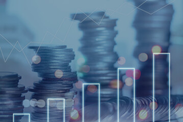 Double exposure of coins stack with financial graph over night cityscape background showing business growth and data analysis and planning to improve sales to reach the goals.