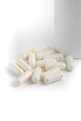 Close-up of a couple white pills or capsules on isolated white background.