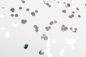 round silver confetti on white background flat lay text place .