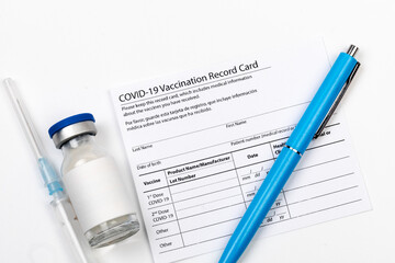 Covid-19 vaccine vial, vaccination record card, syringe, a pen  Coronavirus vaccination concept. - Image