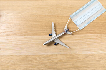 Airplane in flight with a medical mask. Concept - observance of safety on the plane. Traveling by air at social distance - Image