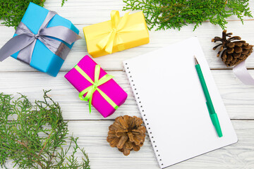 Blank open notepad, pine branches and Christmas decorations on a white wooden table. Space for text. Top view. Flat lay style...- Image