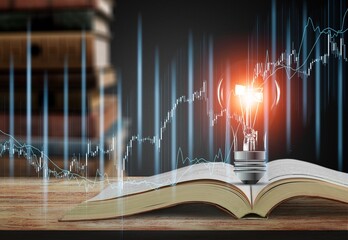 Light bulb and opened vintage book and Stock market or forex trading graph