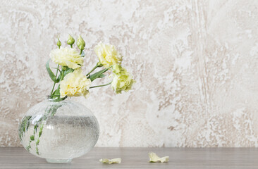 yellow eustoma in  glass vase on table