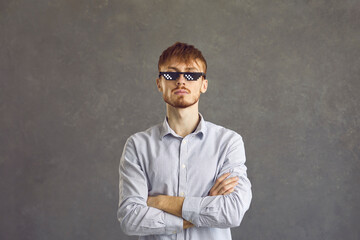 Haughty bearded film fan with pixel glasses, person with cross his arms, portrait, gray background....