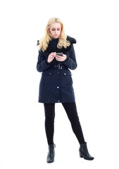 full length portrait of blonde woman wearing long winter coat. and casual clothes. standing pose, isolated on a white studio background.