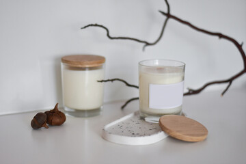 Two handmade natural soy or coconut candles in glass cups on a concrete stand. crackling wick. natural