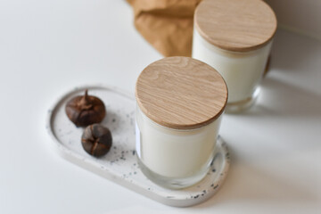 Two handmade natural soy or coconut candles in glass cups on a concrete stand. crackling wick....
