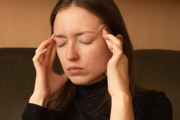 Portrait of stressed young brunette woman massaging temples, feeling strong headache pain or...