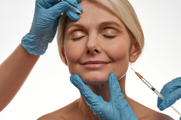 Doctor hands make injection on face of woman