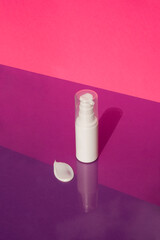 Plastic white bottle with pump for lotion and the appearance of the texture of the cream on a...