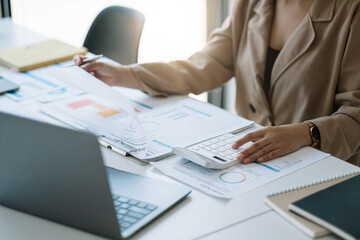Close up woman planning budget, using calculator and laptop, reading documents, young female...