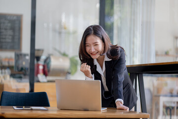 Woman gesturing and looks at laptop screen, businesswoman checking company monthly sales and pretending to be happy as sales meet planned targets according to policy. Sales management concept.