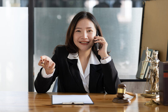 A woman on the phone, she is a lawyer to defend the case, she gives advice on the phone to a client who calls to discuss a company employee embezzlement lawsuit. Lawyer concept and justice.