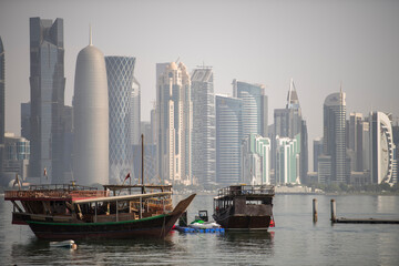 Fototapeta na wymiar Doha,Qatar- December 23,2018 : Traditional dhow boats with the futuristic skyline of Doha in the background.