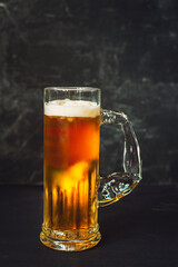Mug of beer on black background, close up