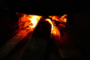 Firewood burns inside the fireplace with fire and smoke
