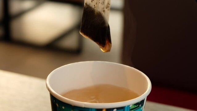 Tea bag in the water in paper cup