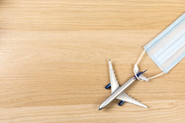 Airplane in flight with a medical mask. Concept - observance of safety on the plane. Traveling by air at social distance - Image