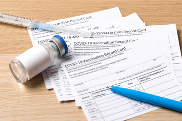 Covid-19 vaccine vial, vaccination record card, syringe, a pen  Coronavirus vaccination concept. - Image