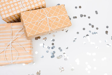 gifts or presents boxes silver confetti on white table top view. Flat lay composition for birthday, christmas or wedding. - Image