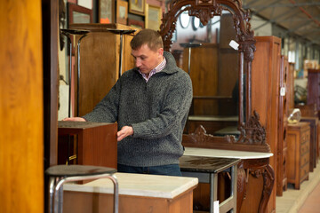 Portrait of young man looking for furniture at showroom