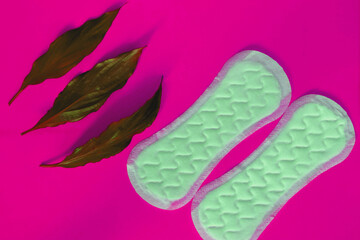 women's pads with leaves on a pink background 