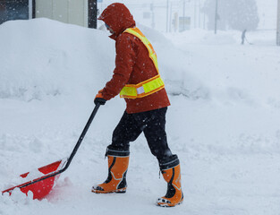 冬に雪寄せ作業をしている男性　スノーダンプ