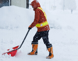 冬に雪寄せ作業をしている男性　スノーダンプ