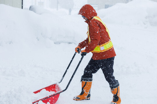 冬に雪寄せ作業をしている男性　スノーダンプ