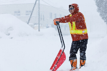 冬に雪寄せ作業をしている男性　スノーダンプ