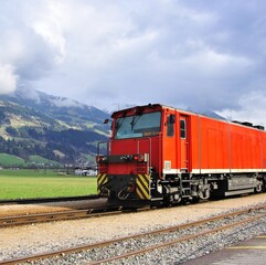Obraz premium Old fashioned red train in austrian Alps on summer