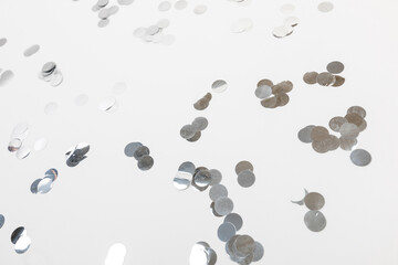 round silver confetti on white background flat lay text place .